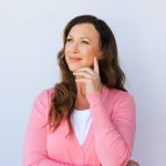 A pensive woman in a pink top.