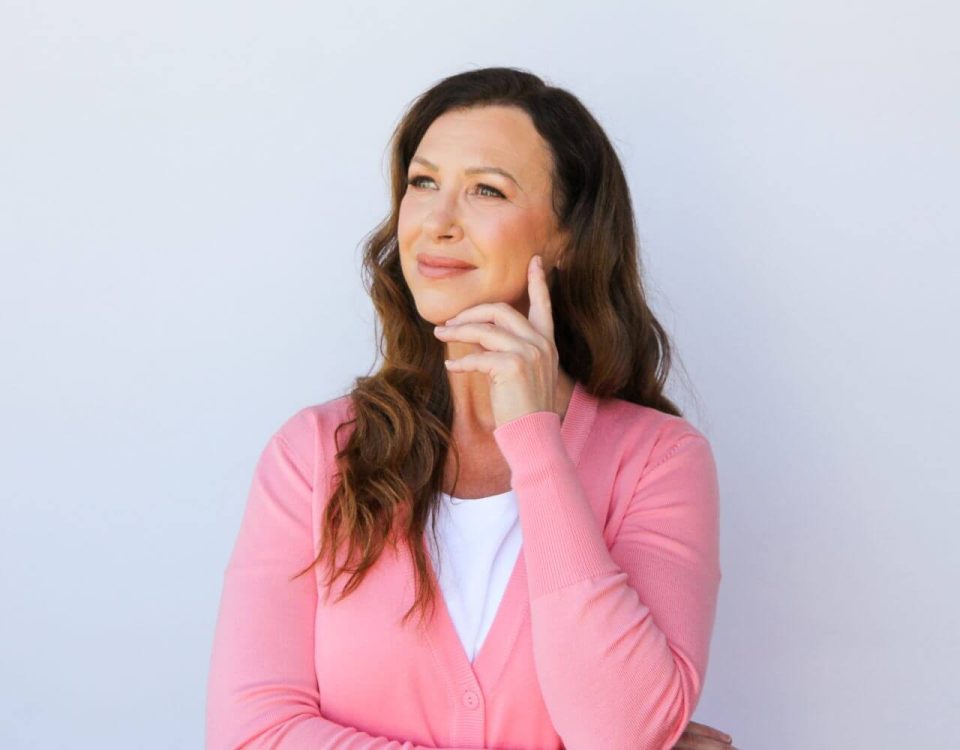 A pensive woman in a pink top.