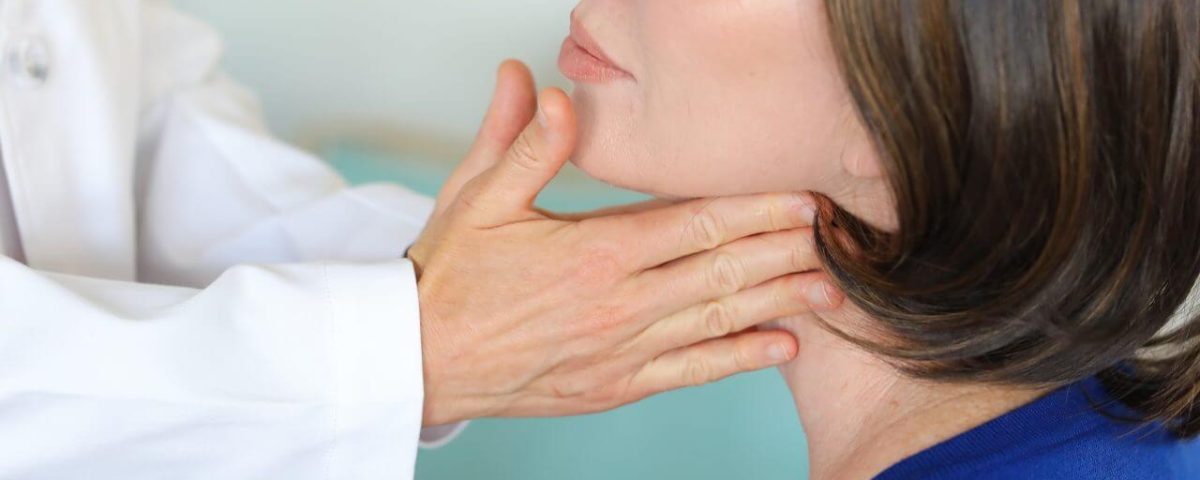 A woman having a thyroid examination.